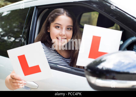 Portrait von Jugendmädchen vorbei fahren Prüfung Holding Lernenden Platten Stockfoto