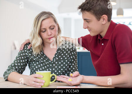 Sohn helfen Eltern Leiden mit psychischen Problemen mit Medikamenten Stockfoto