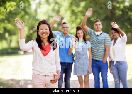 Gruppe von Happy internationale Freunde winkende Hände Stockfoto
