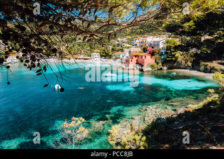 Schöne Bucht von assos Dorf, Kefalonia, Griechenland. Blick auf tourquise transparentes Wasser eingerahmt zwischen Green Pine Grove Branchen. Tiefe dunkle Muster auf lag Stockfoto