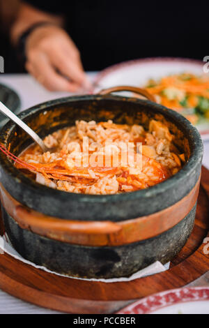 Nationale Küche von Kap Verde: Cachupa mit Garnelen in traditionellen Stein Schüssel. Stockfoto