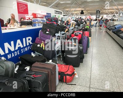 Einige von über Tausend verlassenen Koffer am Flughafen Stansted, Essex, links am Sonntag Nachmittag warten, von Passagieren, deren Gepäck im Reisen Chaos am Wochenende verloren gesammelt werden. Mehr als tausend Koffer liegen in der Gepäckausgabe am Flughafen Stansted aufgegeben Heute (Sonne) nach einem Wochenende von travel Chaos. Hunderte von herrenlosen Taschen und Koffer in der Gepäckausgabe links nach Ryanair annullierte Flüge nach dem Gewitter am Freitag. Die Billigfluglinie annullierte Flüge am Freitag, Samstag und heute, dass hunderte von Urlaubern rauchend. Flüge Stockfoto