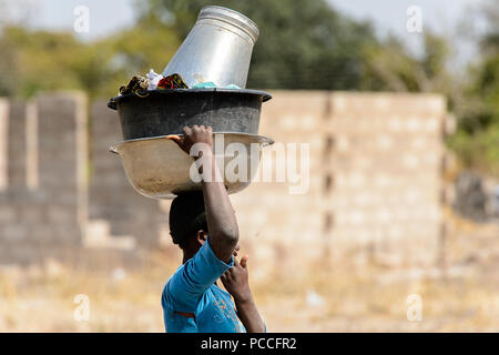 TECHIMAN, GHANA - Jan 15, 2017: Unbekannter ghanaischen Frau trägt Becken auf den Kopf in die Waschmaschine Tag, die jeden Sonntag Stockfoto