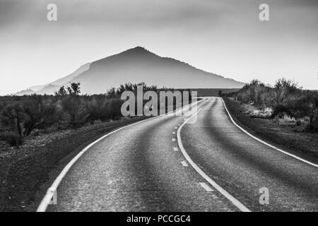 Biegen Landschaft Straße, die zu einem wunderschönen Berg in Schwarz und Weiß Stockfoto