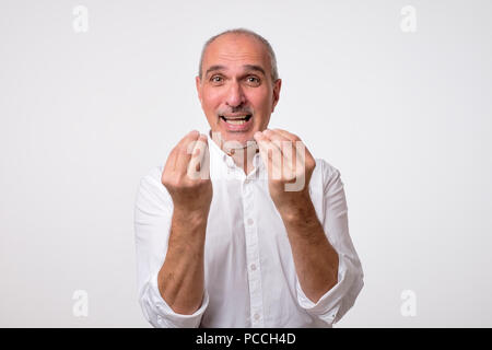 Portrait von Reifen gutaussehenden Mann im weißen Shirt, italienische Geste Stockfoto