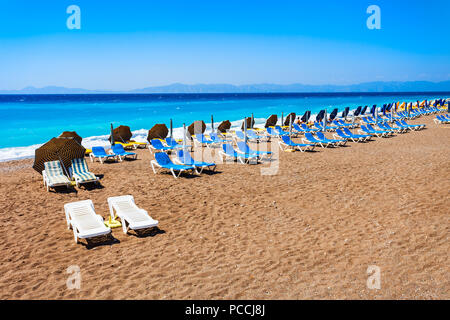 Sonnenliegen mit Sonnenschirmen am Rhodos Stadt Strand auf der Insel Rhodos in Griechenland Stockfoto