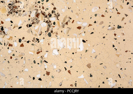 Abstrakte Textur des Alten künstlichen Marmor Hintergrund mit weißen und schwarzen Partikeln. Beige Mosaikboden mit Stein Einsätze und Risse. Stockfoto