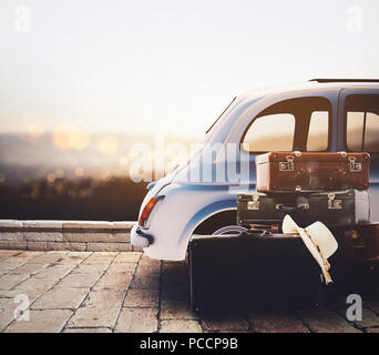 Auto auf der Straße bereit für Sommerurlaub bei Sonnenuntergang mit Gepäck Stockfoto