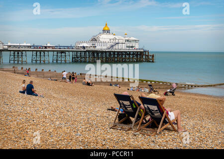 Liegestühle am Eastbourne Beach & Pier Stockfoto