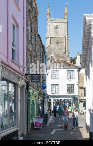 Urlauber in Webb Street, Fowey, Cornwall, England, Großbritannien. Der Turm von Fowey Pfarrkirche im Hintergrund. Stockfoto