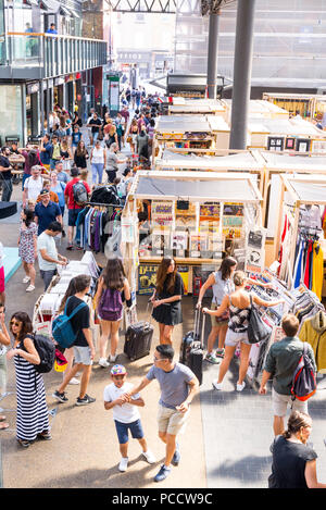 Leute, Shopping und Wandern rund um die Stände im Old Spitalfields Markthalle. Spitalfields, East London, Großbritannien Stockfoto