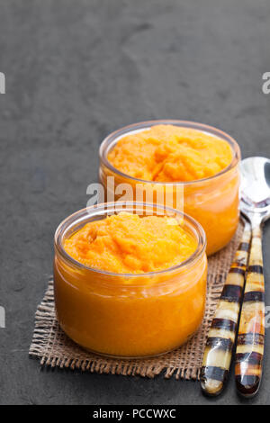 Orange Gemüse Pürieren in Gläsern auf schwarzen Stein Hintergrund Stockfoto