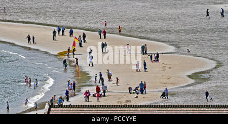 Verschiedene Menschen, verschiedene Dinge - ein Lowry Szene auf dem Sand von Scarborough South Bay Beach. Stockfoto