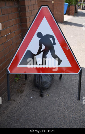 Alte, verwitterte, rote und weiße dreieckige Verkehrssicherheit zeichen Männer bei der Arbeit auf der Seite der Straße. Schwarze Person auf weißem Hintergrund symbol Graben Stockfoto