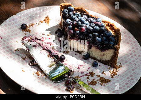 Käsekuchen mit bluberries oben auf Platte mit tortenheber Stockfoto