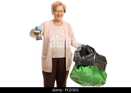 Ältere Frau mit einer Blechdose und einen Müllsack auf weißem Hintergrund Stockfoto