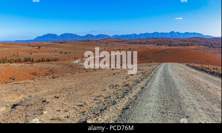 Schotterstraße, die sich durch die Haare orange Hügel in die Berge in Ikara-Flinders Ranges National Park, South Australia Stockfoto