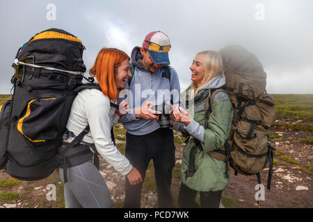 Reisen Lifestyle und Überleben Konzept Sicht nach hinten. Wandern Menschen und Frauen mit Rucksack genießt eine Wanderung und schaut sich die Bilder auf der Kamera in der m Stockfoto