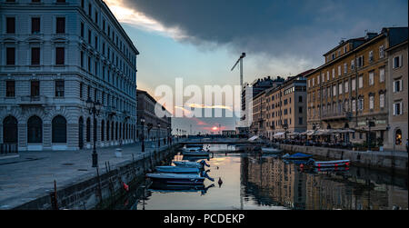 Triest, Italien, vom 31. Juli 2018. Die Sonne über der Adria vom Canal Grande in der Innenstadt von Triest gesehen. Die schiffbaren Kanal, unterschiedl Stockfoto