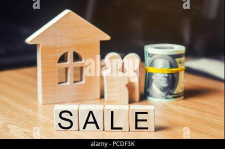 Konzept der Immobilien. Modell des Hauses, der Familie, der Dollar und der Inschrift "Verkauf" auf Holzblöcken. Familie bewegt und ein Haus oder eine Wohnung verkauft Stockfoto