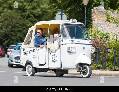 Menschen mit einer Stadtführung in einem Piaggio Ape Calessino 3 Wagen mit Rädern (allgemein als ein Tuk Tuk Fahrzeug bezeichnet) von Tukzi Touren in Arundel, West Sussex, UK. Stockfoto