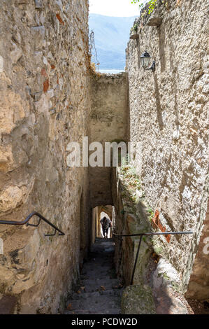 Mann an einem steilen Treppen aus Stein in der Altstadt von Limone, Italien. Stockfoto