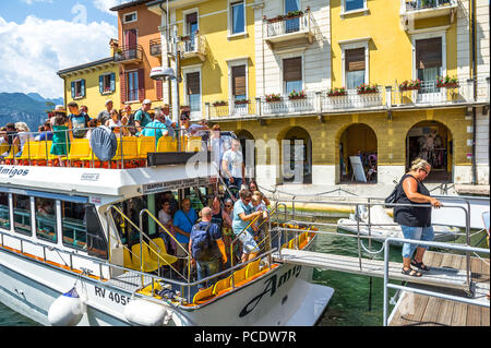 Passagiere verlassen ein kleines Boot in Malcesine am Gardasee. Stockfoto