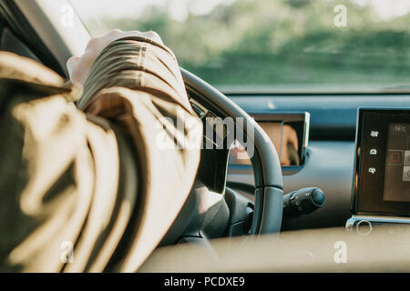 Close-up. Die Hand des Fahrers auf das Lenkrad. Der Treiber oder Reisenden oder Tourist ist ein Auto fahren. Reiten im Alltag oder auf Reisen. Stockfoto