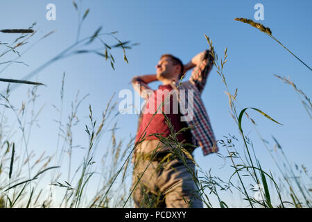 Junge kaukasier gutaussehenden Mann in einem Feld bei sunse Stockfoto