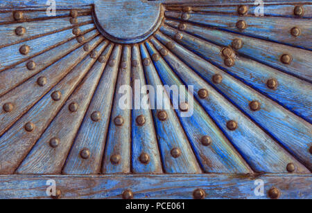 Kunstvolle Holz- Muster mit metall nieten. Relief Holz- Teil der alten Tür mit Geometrisches Ornament in Form der Sonne mit Strahlen. Stockfoto