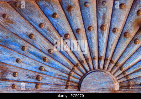 Kunstvolle Holz- Muster mit metall nieten. Relief Holz- Teil der alten Tür mit Geometrisches Ornament in Form der Sonne mit Strahlen. Stockfoto
