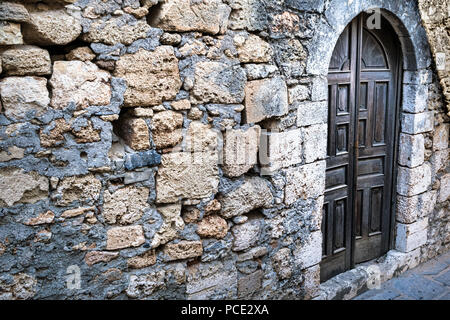 Bild einer Holztür am Eingang zu einem alten Rustikales Steinhaus. Stockfoto