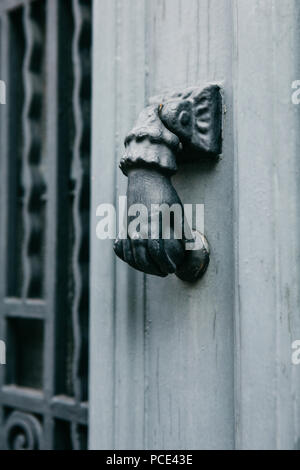 Close-up. Vintage Griff für Klopfen an der Tür in der Form einer Hand. Eingang zum Gebäude. Stockfoto