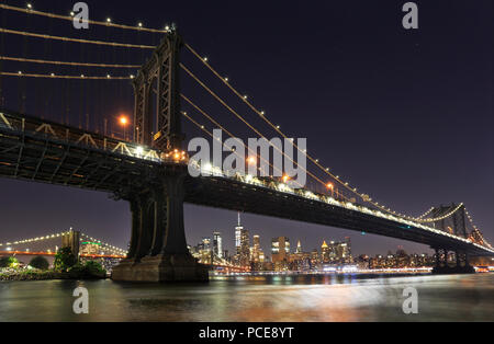 Panorama von Manhattan und Brooklyn Brücken und New York City mit Licht und Reflexionen in der Nacht, USA Stockfoto