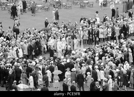 Königin Elizabeth II. geht mitten unter ihren Gästen bei einer Gartenparty am Buckingham Palace. Stockfoto