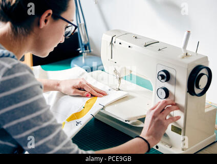 Frau mit elektrischen Nähmaschine Vorhänge zu machen Stockfoto