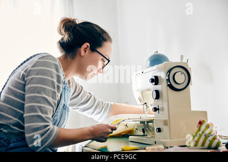 Frau mit elektrischen Nähmaschine Vorhänge zu machen Stockfoto