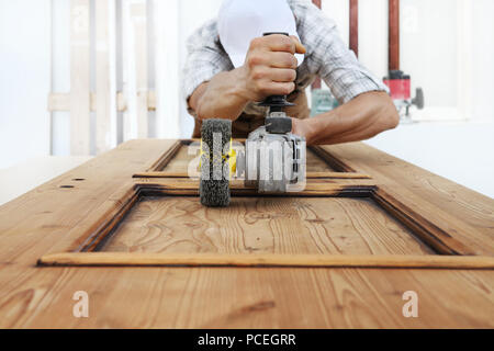 Holzarbeit das Holz mit dem Schleifer schleifen Elektrowerkzeuge für rustikale Renovieren Stockfoto