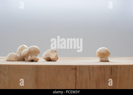 Gruppe von Pilzen auf einer hölzernen Schneidebrett mit einem Pilz auf der rechten Seite Stockfoto