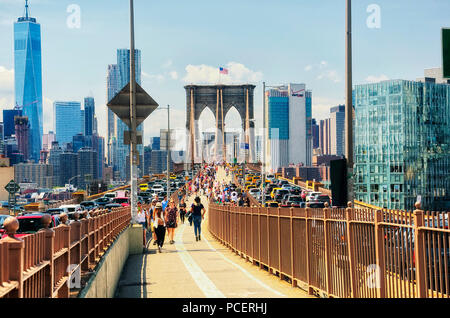 Juni 10, 2017. New York City, New York. Toursts und Verkehr auf der Brooklyn Bridge und die Skyline von New York City an einem sonnigen Tag im Sommer. Stockfoto