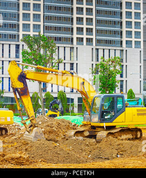 Bagger graben Boden an Industrie in Singapur Stockfoto