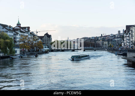 Stadt Zürich Panorama mit Limmat und kleinen Kreuzfahrtschiff am Abend Stockfoto