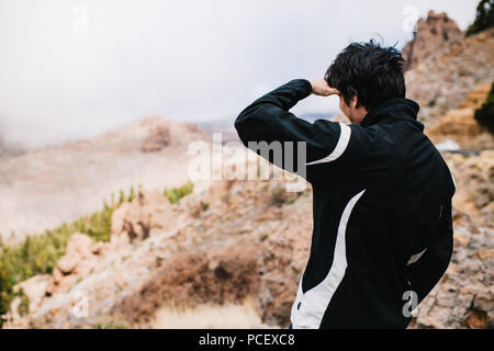 Junger Mann auf der Suche vulkanische Landschaft von einem Nationalpark Teide Weltkulturerbe an die Kanarischen Inseln Stockfoto