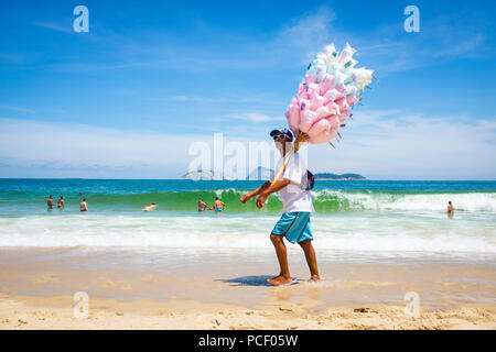 RIO DE JANEIRO, BRASILIEN - ca. März 2018: brasilianischen Strand Anbieter verkaufen Baumwolle Zuckerwatte Spaziergänge am Strand von Ipanema Stockfoto