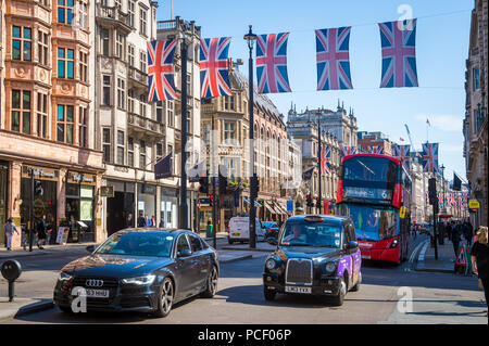 LONDON, UK, 15. Mai 2018, Union Jack Flagge hängt über besetzt Piccadilly Street wie ein iconic black cab verläuft vor Doppeldecker Stockfoto