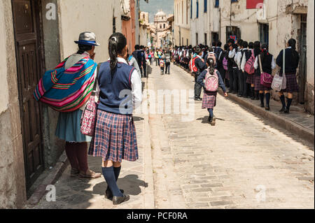 Gruppe von Kindern in die Morgen zur Schule. Tragen bunte traditionelle Kleidung, die Straße hinunter in Schuluniform in Cusco, Peru. Stockfoto
