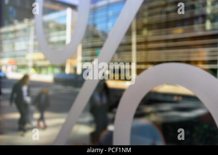 Familie mit Kindern und modernen Gebäuden auf der Straße sind, werden im Fenster mit einem Prozentzeichen wider. Verschwommen Stockfoto