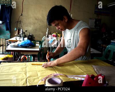 ANTIPOLO CITY, Philippinen - Juli 30, 2018: ein Schneider schafft ein Muster für ein Kleid an seinem Tailoring Shop. Stockfoto