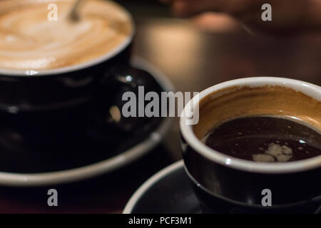 Nahaufnahme von zwei dunklen Braun Tassen Kaffee auf einem dunklen Hintergrund Stockfoto
