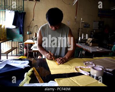 ANTIPOLO CITY, Philippinen - Juli 30, 2018: ein Schneider schafft ein Muster für ein Kleid an seinem Tailoring Shop. Stockfoto